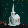 Decorative ceramic church with a candle on a dark background Decorative ceramic church with a candle on a dark background