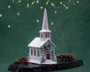 Decorative model of a church with a steeple on a green background